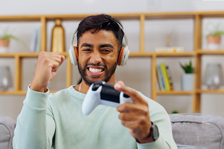 Man on couch looking at TV and gaming